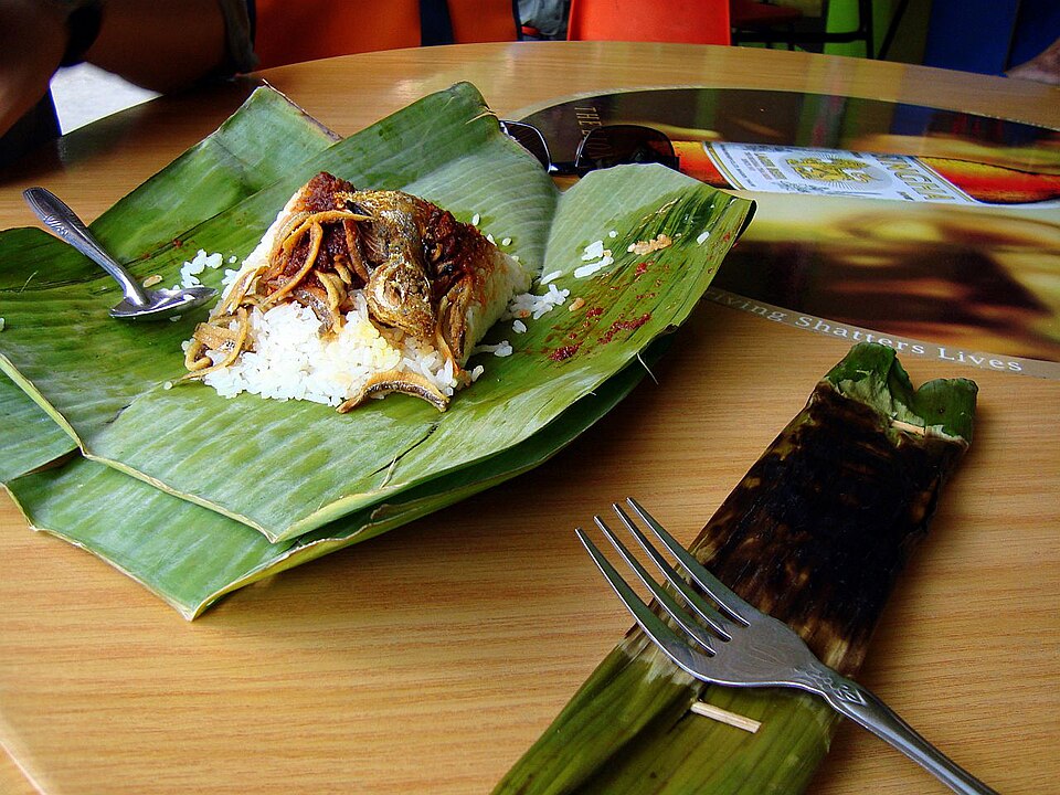 Nasi lemak with sambal and fried fish on an opened banana leaf wrap