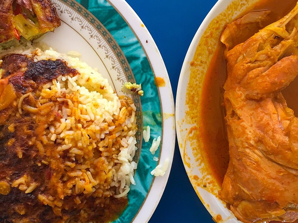 Northern-style nasi lemak with sambal, next to a bowl of chicken curry